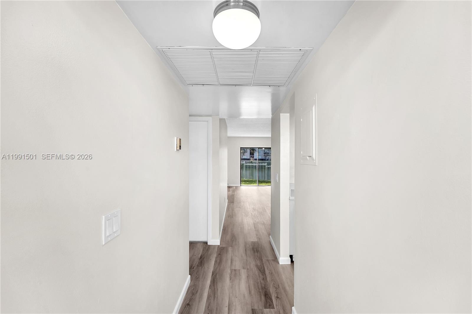 7668 Southwest 152nd Avenue, Unit 2107 Miami, FL 33193 - Photo 3 of 17 a view of a hallway with wooden floor and a chandelier