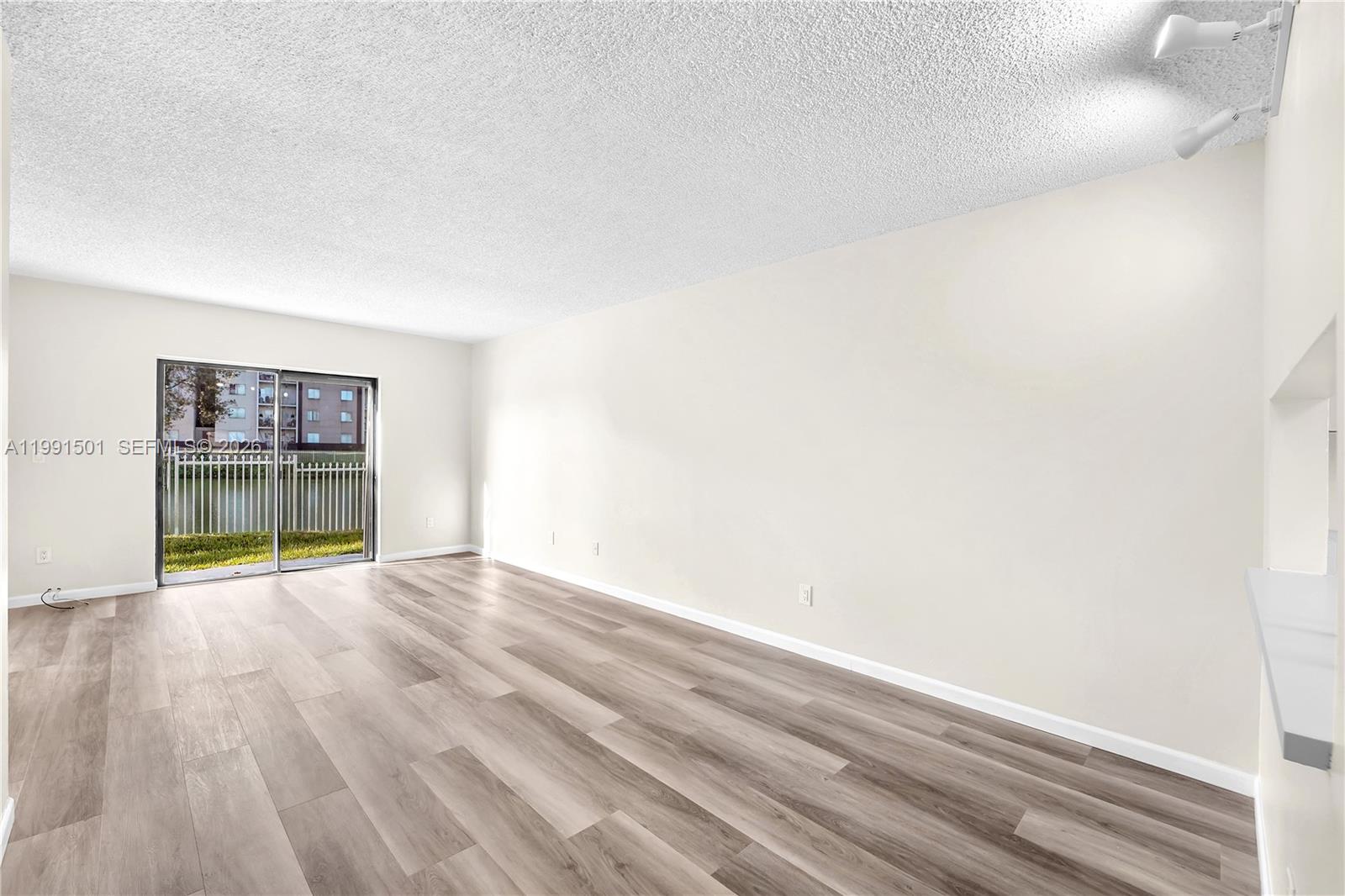 7668 Southwest 152nd Avenue, Unit 2107 Miami, FL 33193 - Photo 4 of 17 a view of empty room with wooden floor and fan