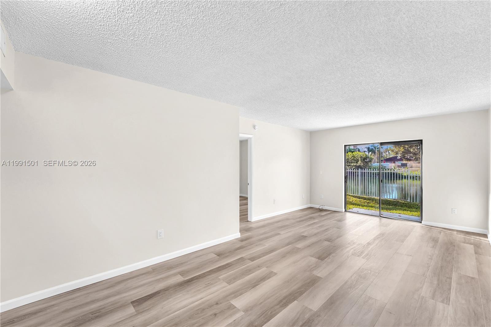 7668 Southwest 152nd Avenue, Unit 2107 Miami, FL 33193 - Photo 5 of 17 an empty room with wooden floor and windows