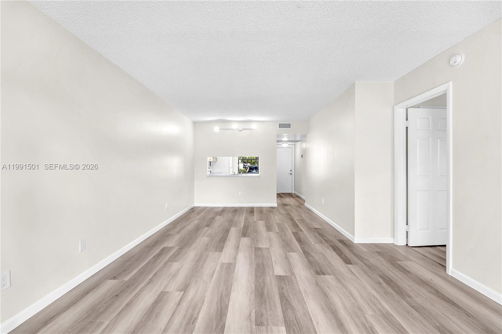 7668 Southwest 152nd Avenue, Unit 2107 Miami, FL 33193 - Photo 10 of 17 a view of a big room with wooden floor and windows