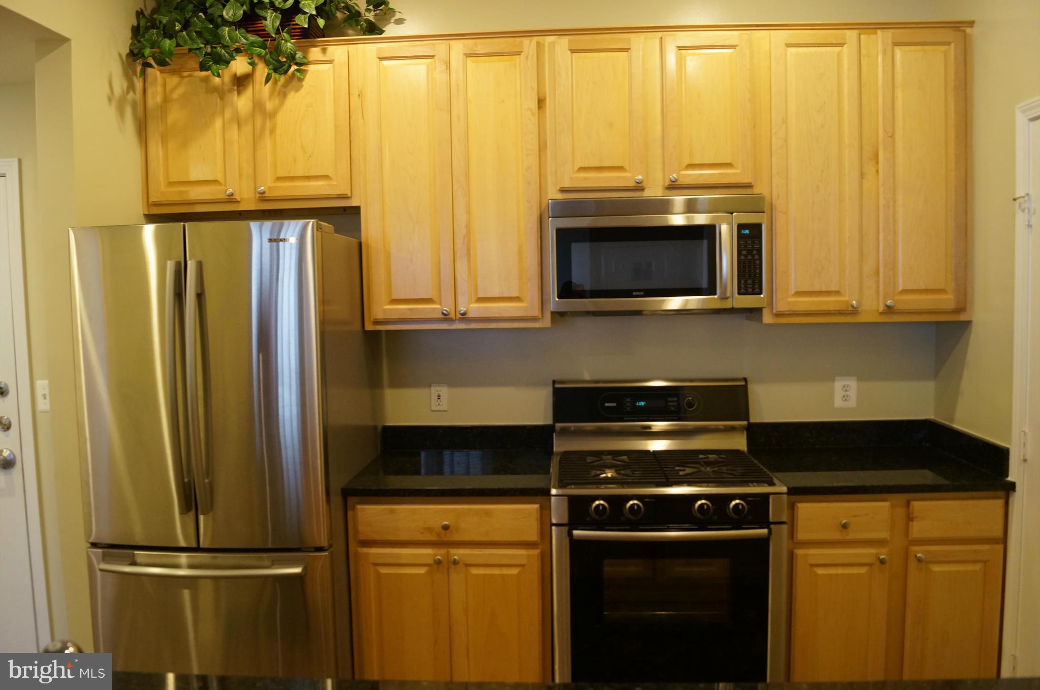 12000 Market Street, Unit 425 Reston, VA 20190 - Photo 11 of 30 a kitchen with granite countertop a stove and a microwave