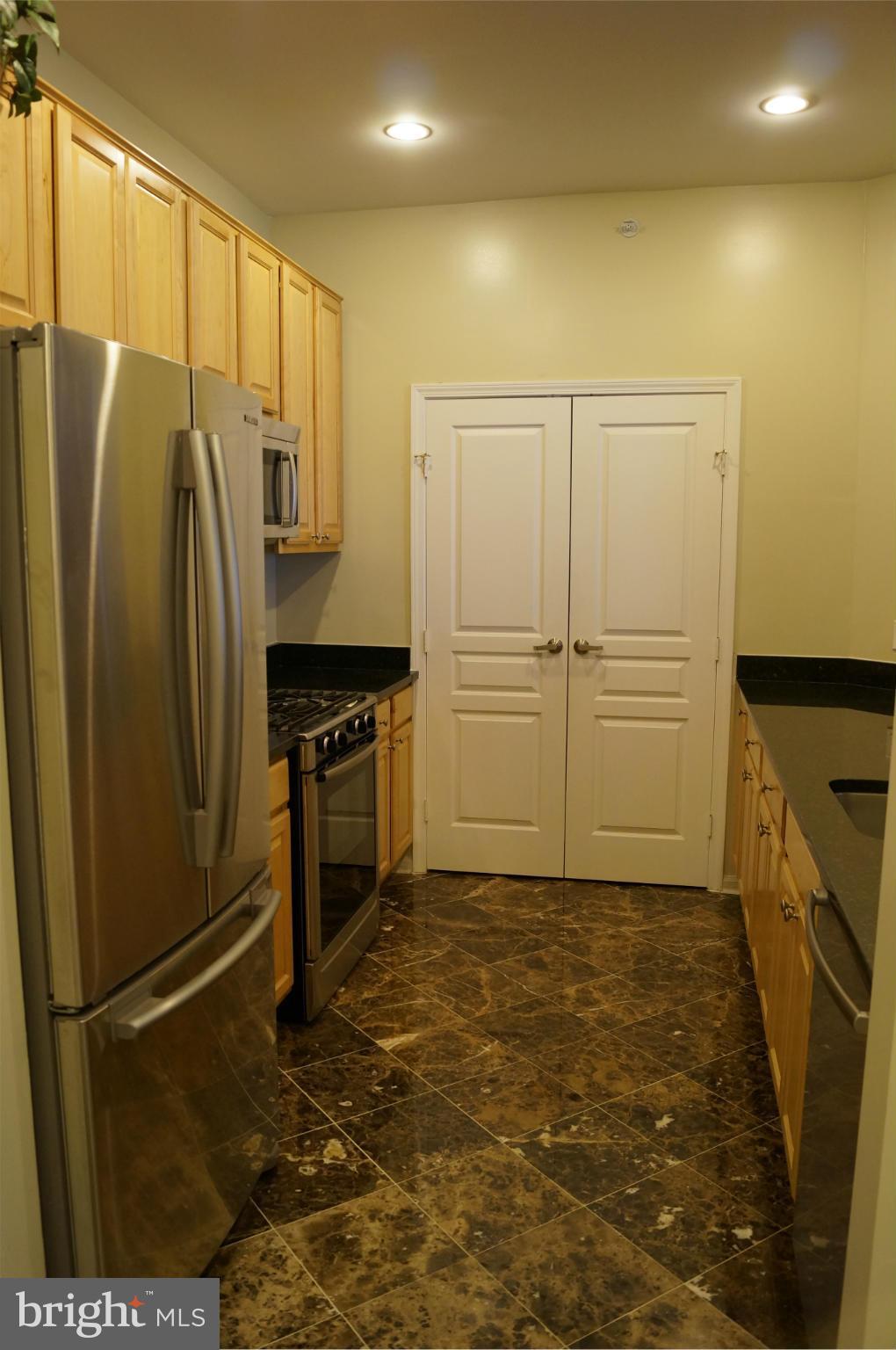 12000 Market Street, Unit 425 Reston, VA 20190 - Photo 12 of 30 a kitchen with stainless steel appliances granite countertop a refrigerator a stove and a sink