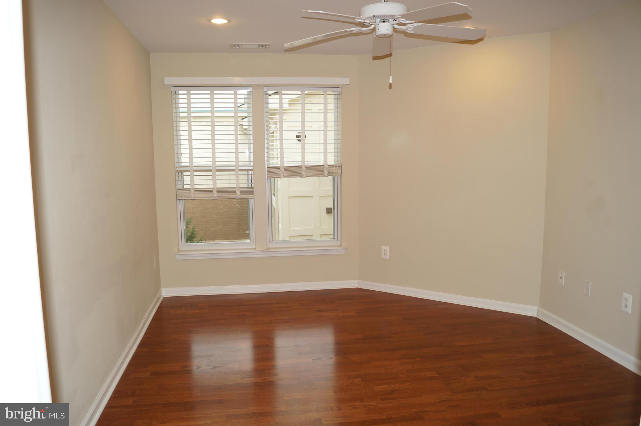 12000 Market Street, Unit 425 Reston, VA 20190 - Photo 18 of 30 an empty room with wooden floor fan and windows