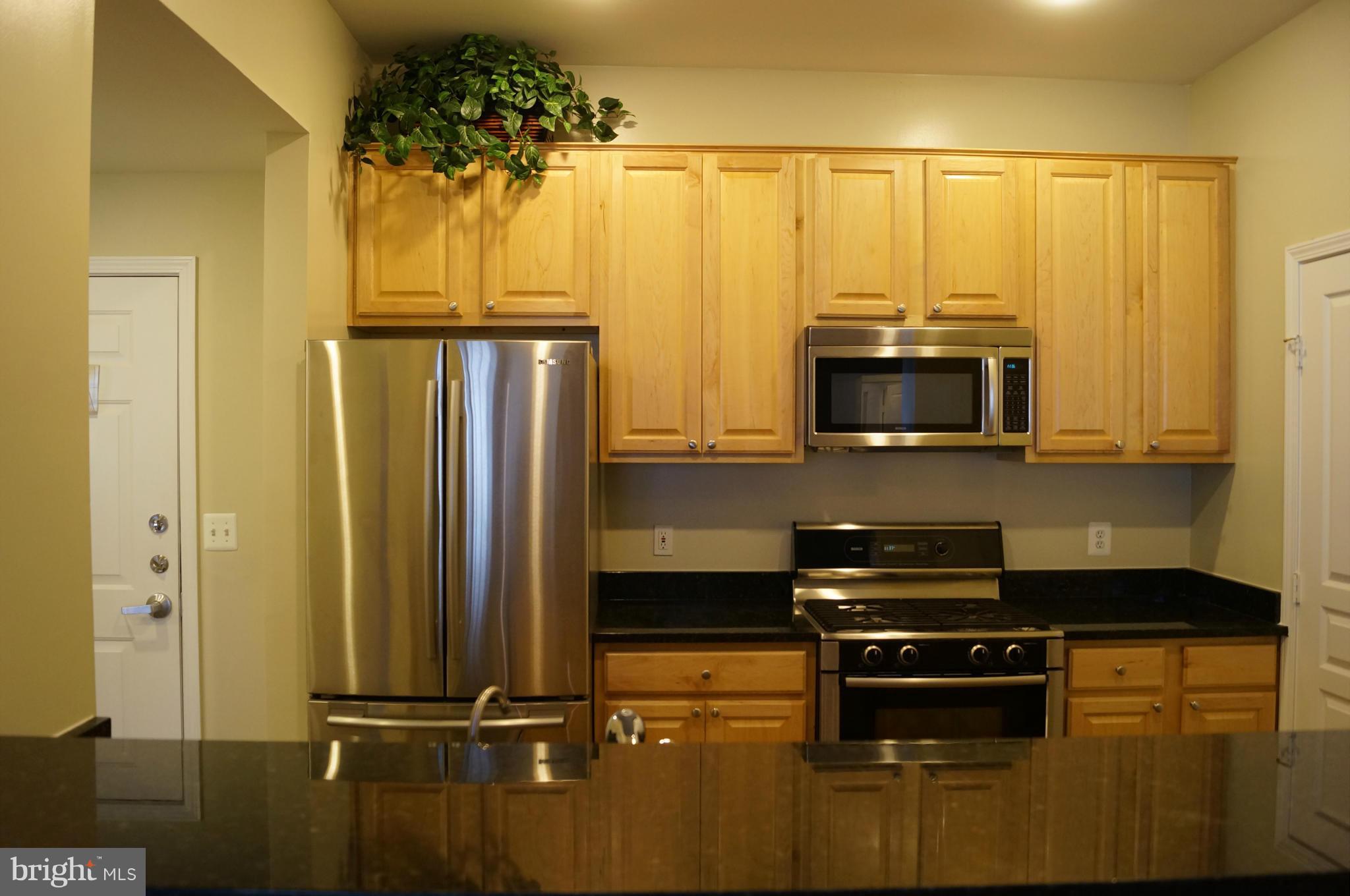 12000 Market Street, Unit 425 Reston, VA 20190 - Photo 21 of 30 a kitchen with stainless steel appliances a microwave a stove and cabinets