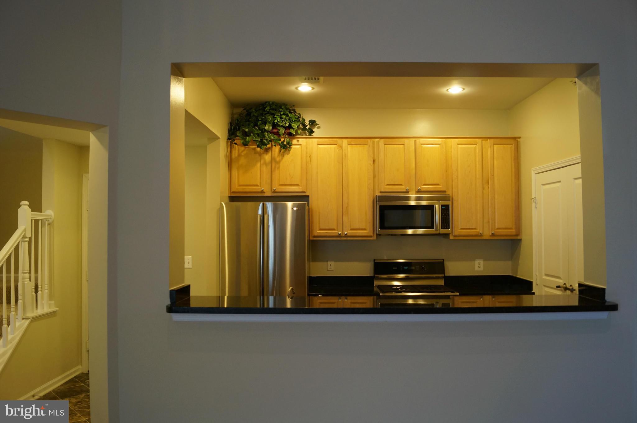 12000 Market Street, Unit 425 Reston, VA 20190 - Photo 22 of 30 a kitchen with a refrigerator and a stove