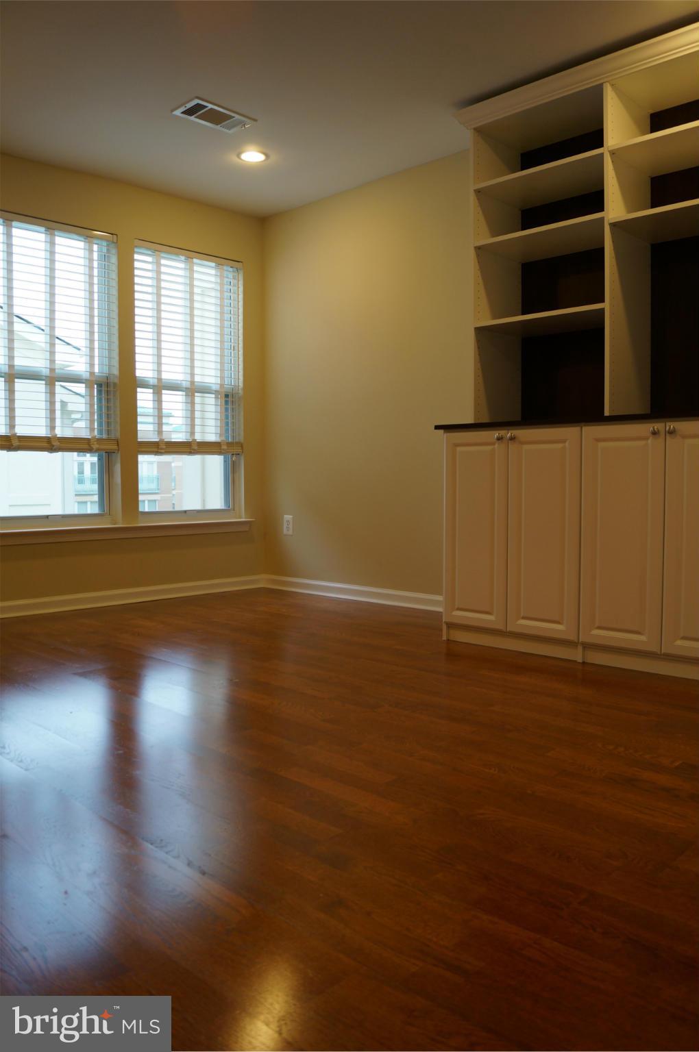 12000 Market Street, Unit 425 Reston, VA 20190 - Photo 26 of 30 an empty room with wooden floor and windows