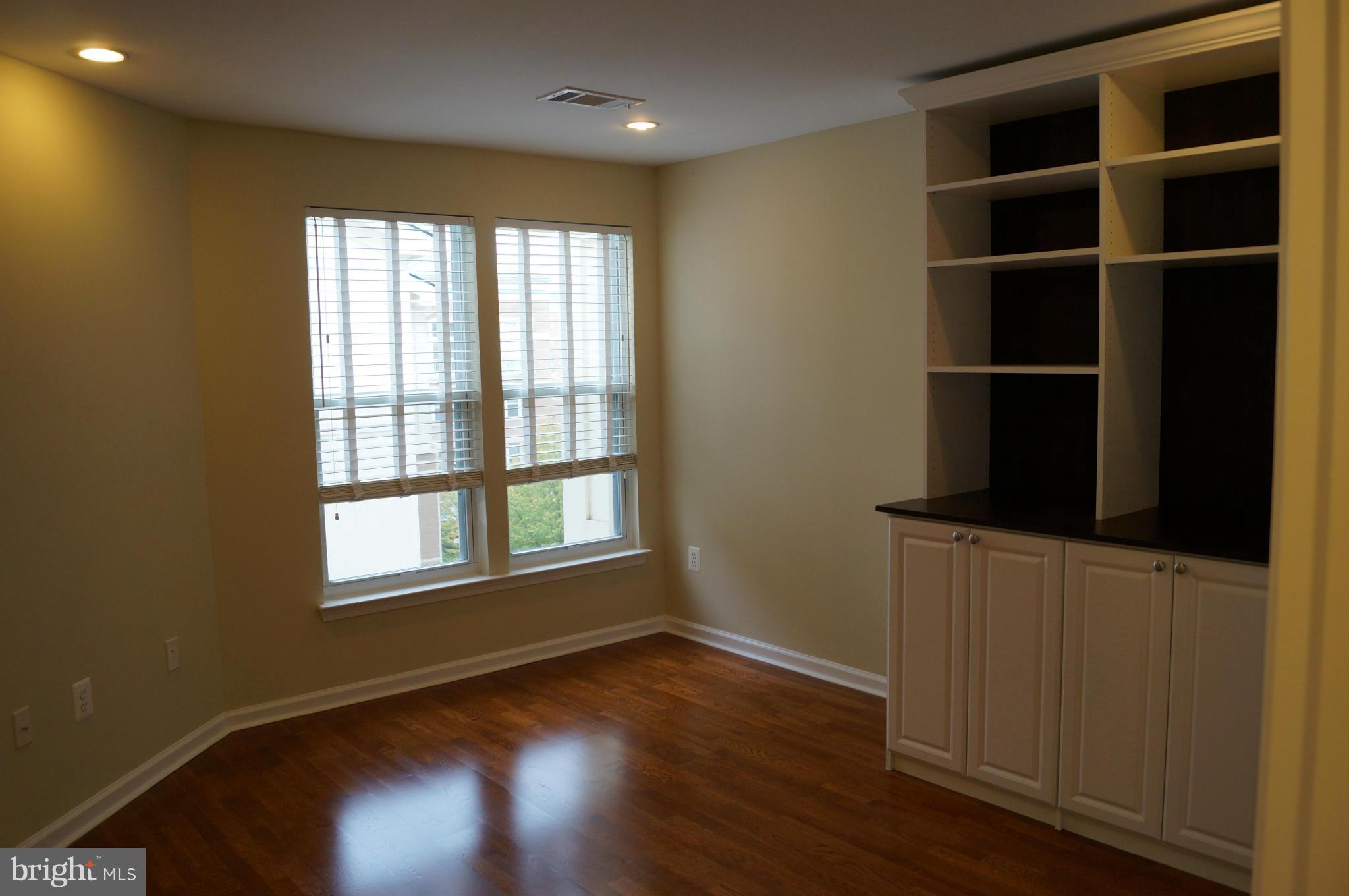 12000 Market Street, Unit 425 Reston, VA 20190 - Photo 7 of 30 a view of an empty room with a window and wooden floor