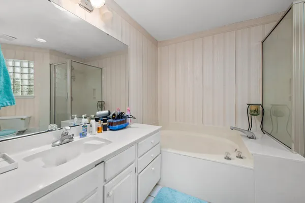 a bathroom with a tub sink and a mirror