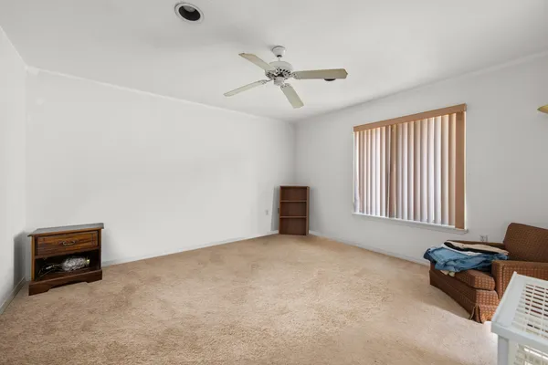 an empty room with windows and ceiling fan