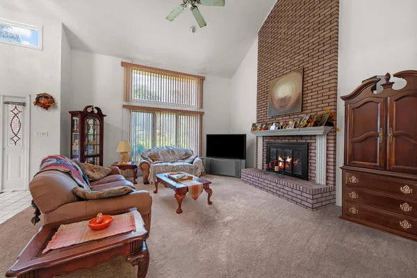 a living room with furniture a flat screen tv and a fireplace