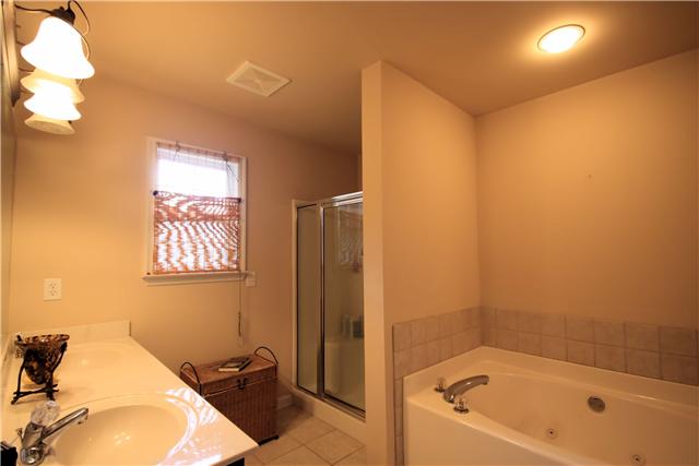 1137 Rip Steele Road Columbia, TN 38401 - Photo 11 of 20 Master Bath Suite has double vanities, tiled backsplash and Jacuzzi tub with a beautiful tile floor.