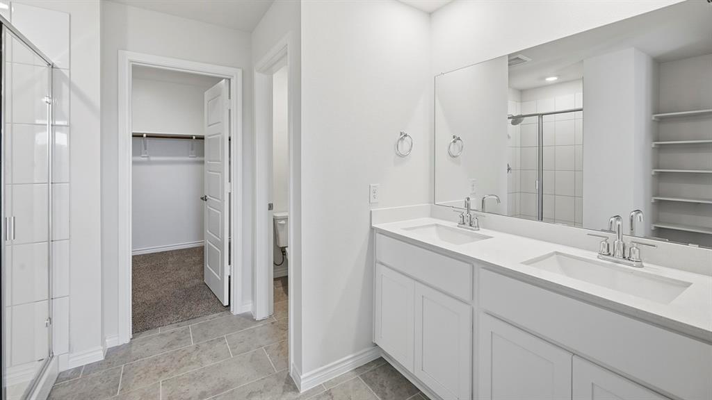 403 Flintlock Road Caddo Mills, TX 75135 - Photo 5 of 26 Bathroom featuring a spacious closet, double vanity, and a stall shower