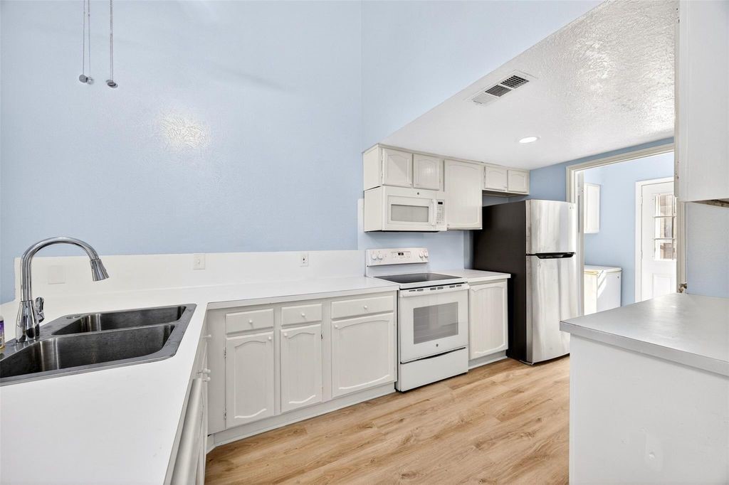 17 April Point Drive North Conroe, TX 77356 - Photo 21 of 42 a kitchen with white cabinets and stainless steel appliances