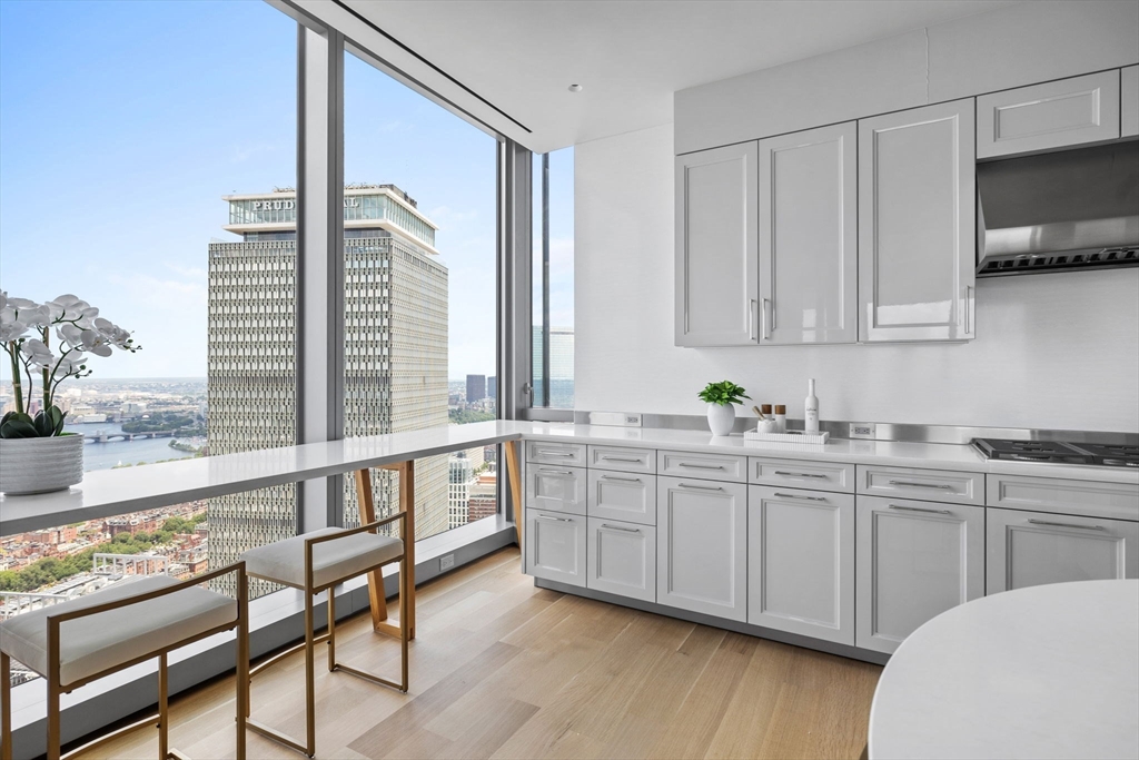 1 Dalton Street, Unit 5101 Boston, MA 02115 - Photo 8 of 31 a large white kitchen with granite countertop a sink and white cabinets