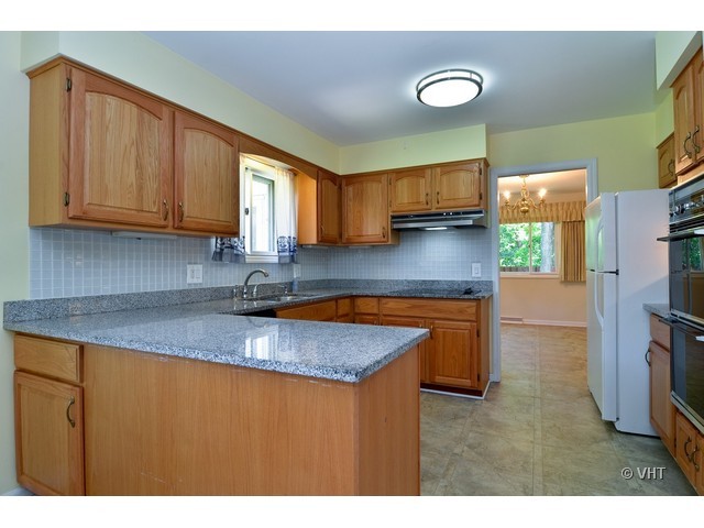 1205 Arbor Vitae Road Deerfield, IL 60015 - Photo 4 of 10 a kitchen with granite countertop a stove a sink and a microwave