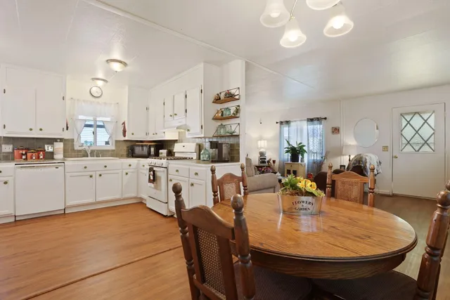 a large kitchen with kitchen island a white table and chairs