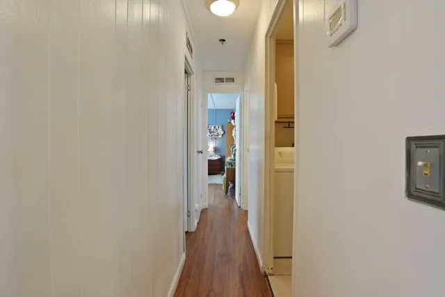 a view of a hallway with wooden floor
