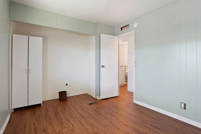 an empty room with wooden floor and closet