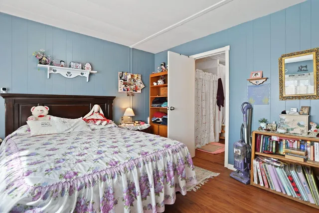 a bedroom with bed and book shelf