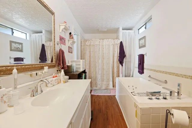 a bath room with a sink tub and a mirror