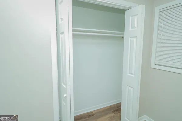 a view of walk in closet with empty racks