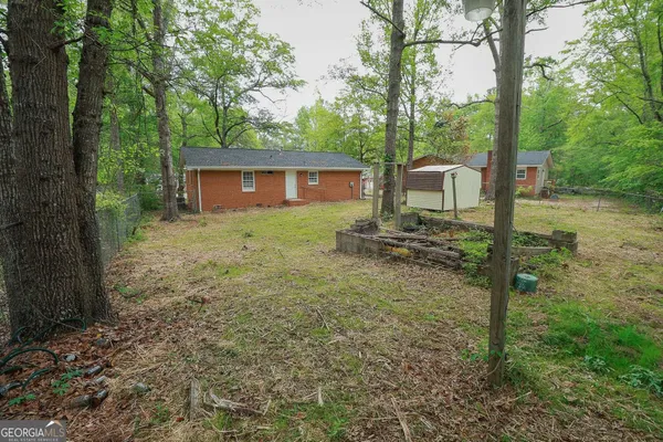 a view of a yard in front of a house with large tree