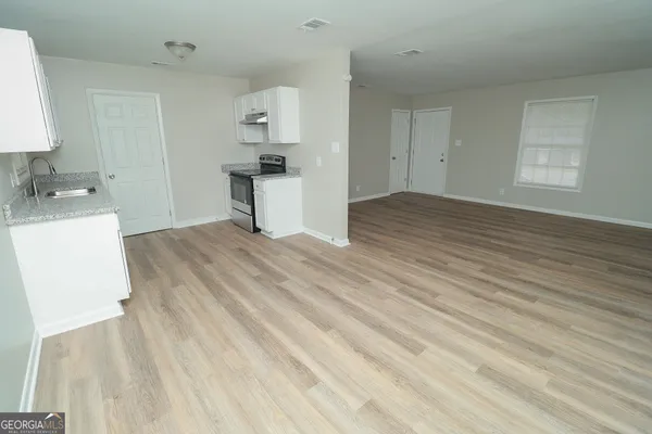 a view of a kitchen with wooden floor and electronic appliances
