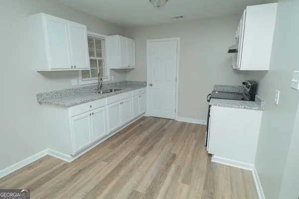 a kitchen with a sink a stove and cabinets