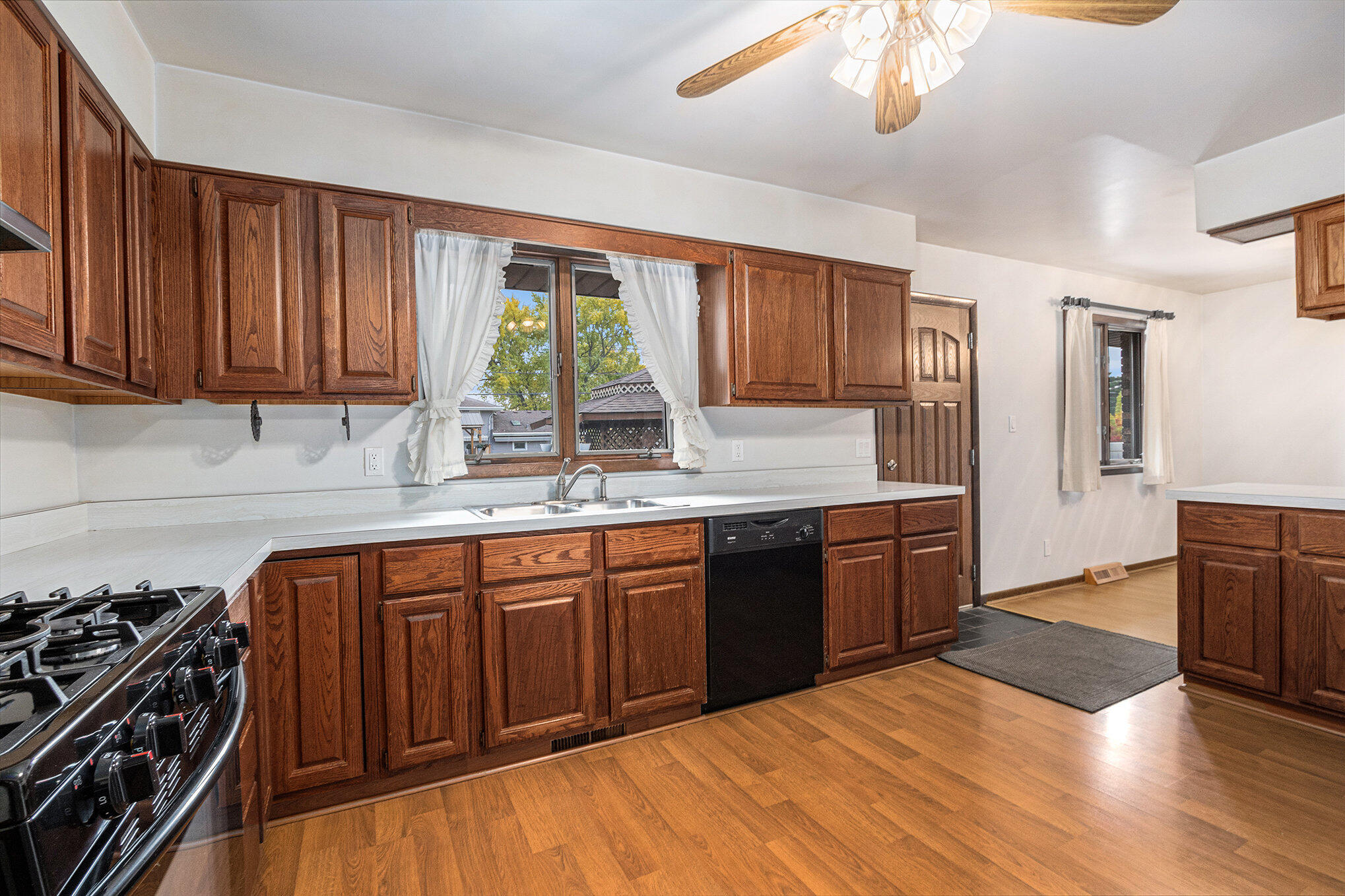 7905 Frederick Avenue Munster, IN 46321 - Photo 4 of 26 a kitchen with stainless steel appliances granite countertop a stove a sink dishwasher and cabinets with wooden floor