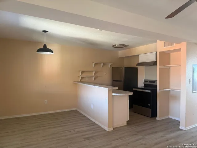 a kitchen with kitchen island white cabinets and wooden floor