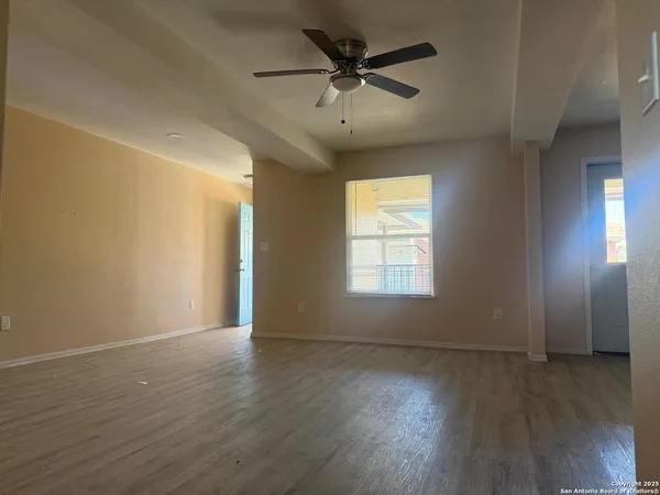 an empty room with wooden floor and windows