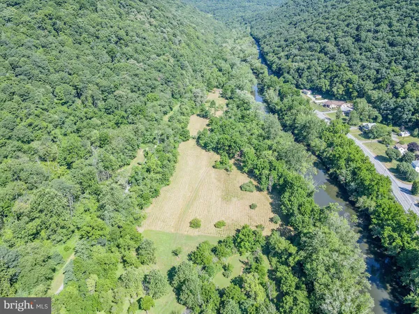 an aerial view of residential house with space and trees all around
