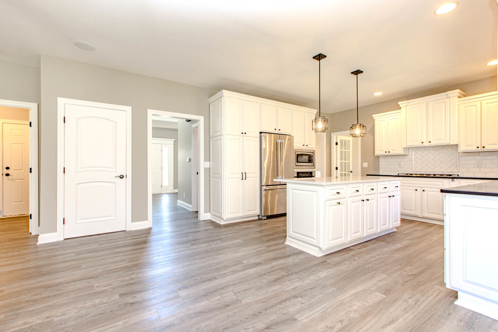 59 Stonebrook Court Bloomington, IL 61704 - Photo 11 of 52 a large white kitchen with a window wooden floor and stainless steel appliances