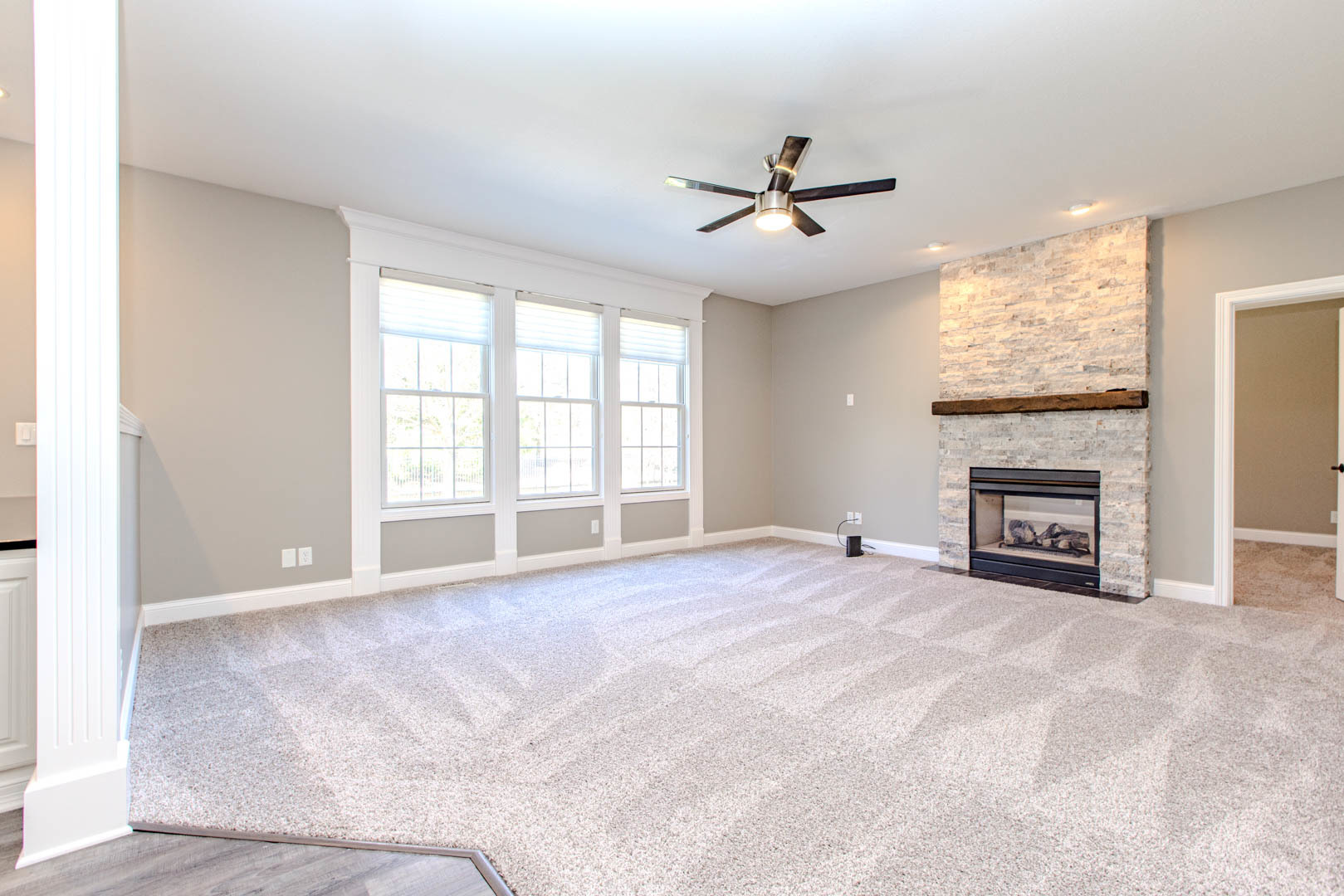 59 Stonebrook Court Bloomington, IL 61704 - Photo 13 of 52 an empty room with windows fireplace and a ceiling fan