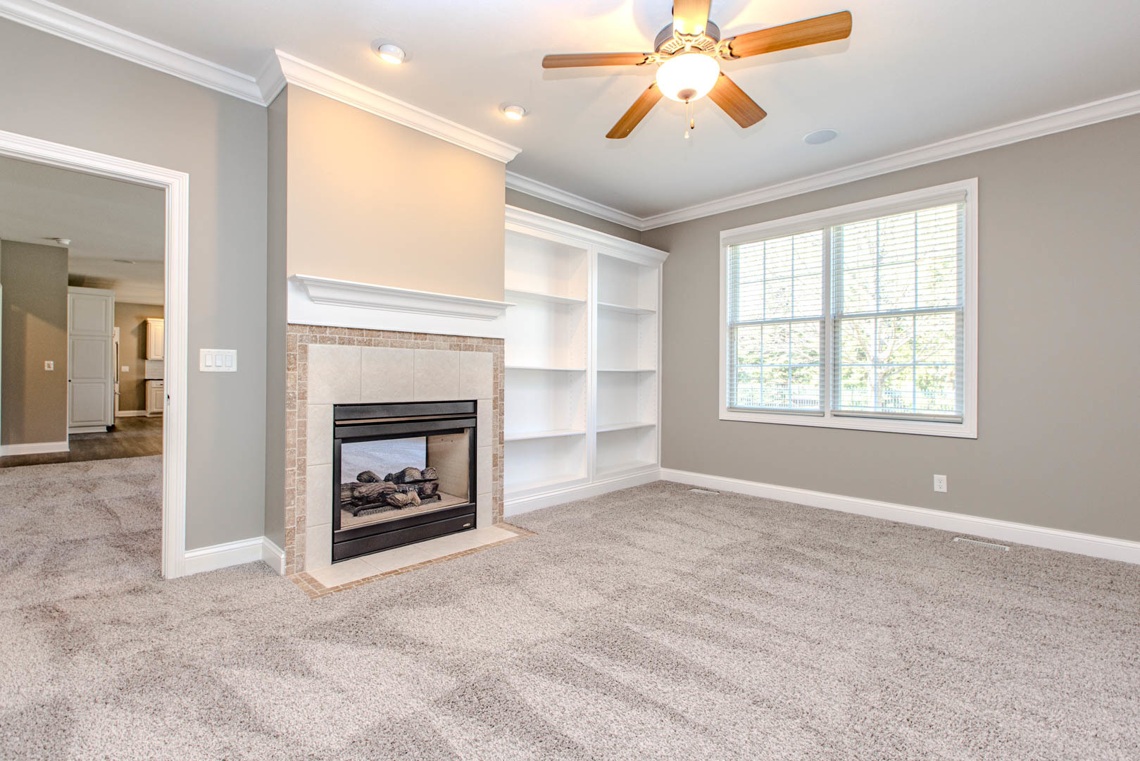 59 Stonebrook Court Bloomington, IL 61704 - Photo 15 of 52 an empty room with windows fireplace and fan