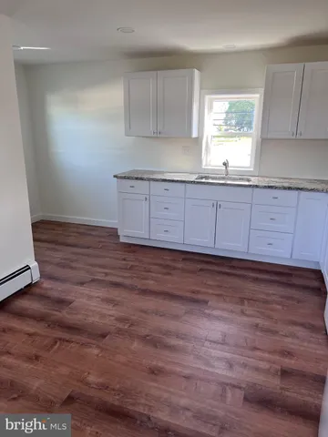a kitchen with granite countertop wooden floors and cabinets