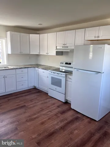 a kitchen with a refrigerator stove top oven and cabinets