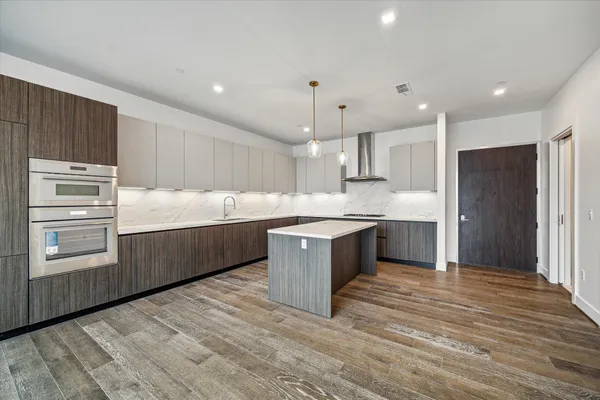 a kitchen with kitchen island a sink stainless steel appliances and cabinets