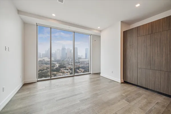 an empty room with sliding door and wooden floor