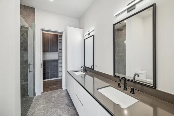 a bathroom with double vanity sink and a mirror