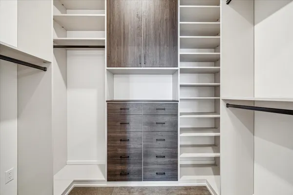 a view of walk in closet with empty racks