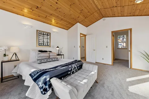 a bedroom with a bed and painting on the wall