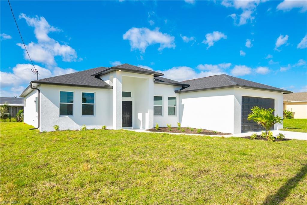 1515 Nelson Road North Cape Coral, FL 33993 - Photo 1 of 38 a front view of a house with a garden