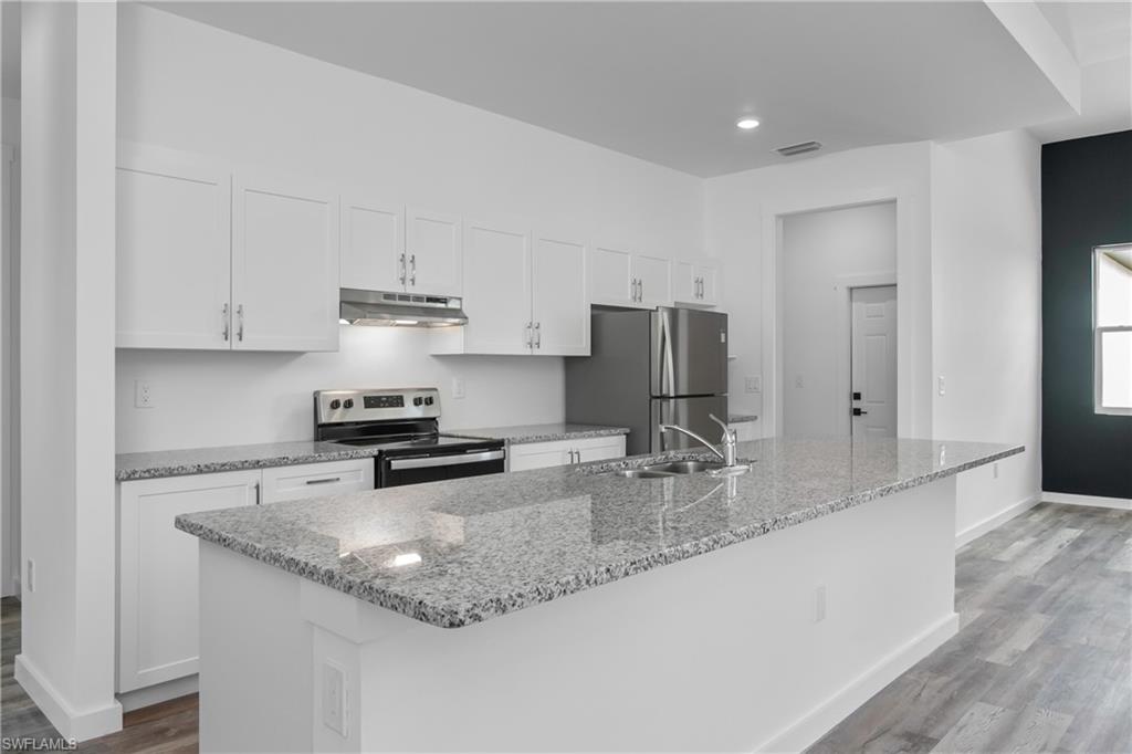 1515 Nelson Road North Cape Coral, FL 33993 - Photo 13 of 38 a kitchen with stainless steel appliances granite countertop a sink refrigerator and cabinets