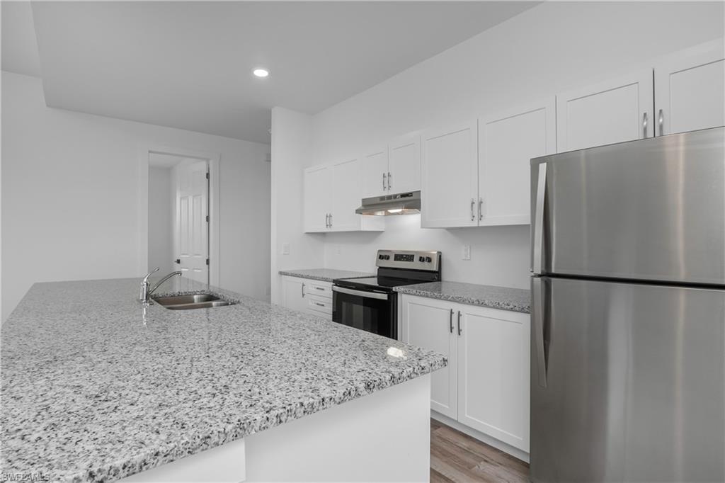 1515 Nelson Road North Cape Coral, FL 33993 - Photo 14 of 38 a kitchen with a refrigerator a stove and a sink