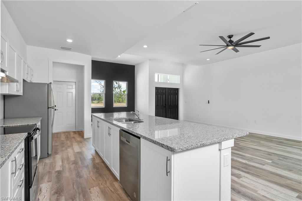 1515 Nelson Road North Cape Coral, FL 33993 - Photo 16 of 38 a kitchen with stainless steel appliances granite countertop a sink and a refrigerator