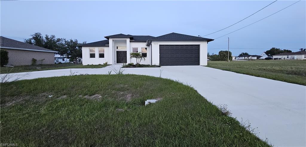 1515 Nelson Road North Cape Coral, FL 33993 - Photo 2 of 38 a front view of a house with a yard and garage