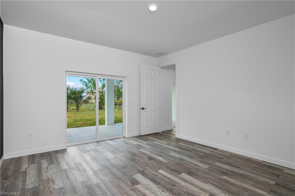 1515 Nelson Road North Cape Coral, FL 33993 - Photo 23 of 38 a view of an empty room with wooden floor and a window