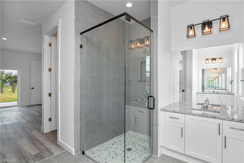 1515 Nelson Road North Cape Coral, FL 33993 - Photo 24 of 38 a bathroom with a granite countertop sink mirror and shower