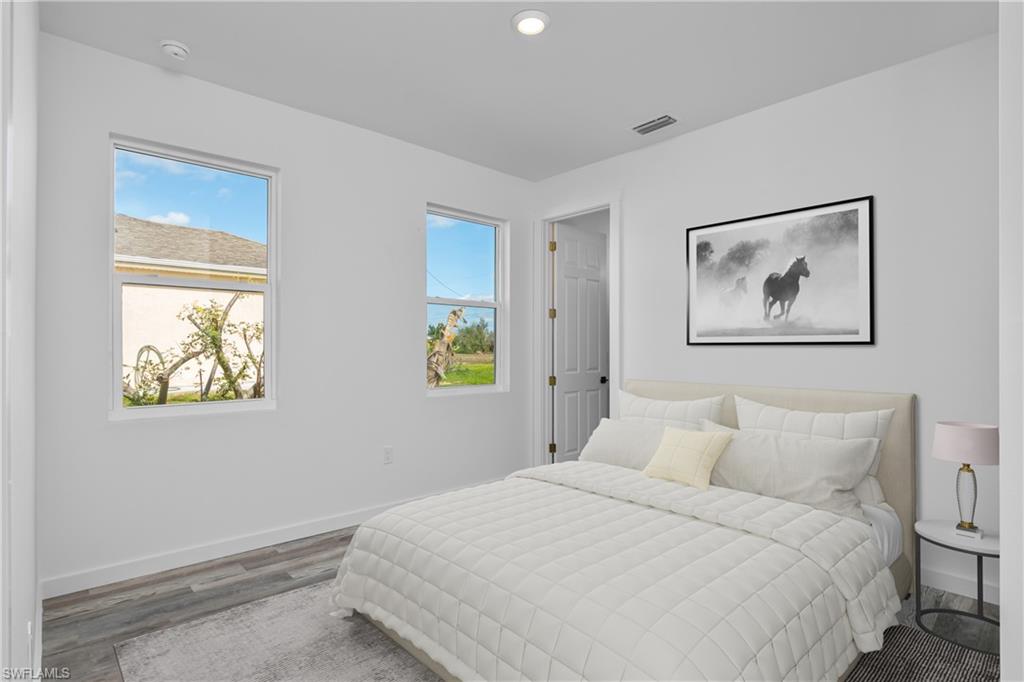 1515 Nelson Road North Cape Coral, FL 33993 - Photo 26 of 38 a bedroom with bed and wall painting with wooden floor